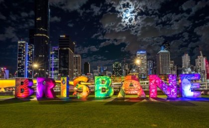 Image: Adobe Large block letters placed on a grass patch, reading the name "Brisbane."